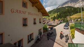 A building with the sign "GARNI BELLAVISTA" and motorcycles parked in front.