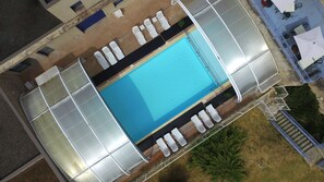 Una piscina al aire libre, una piscina climatizada, sombrillas, tumbonas