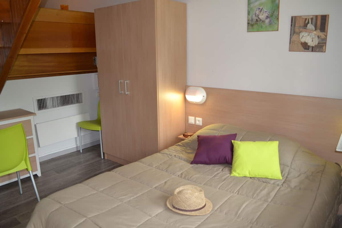 Ein Schlafzimmer mit einem Bett, einem Schreibtisch und einem Stuhl.