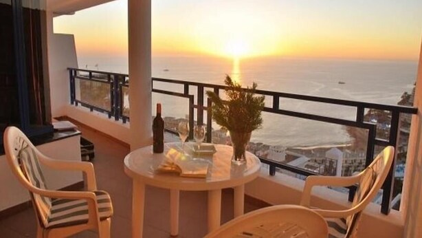 A balcony with a table set for two, overlooking a sunset over the sea. - Balcon de Taurito (Mogan)