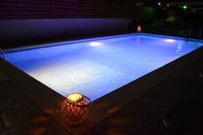 A swimming pool with a single illuminated candle on the edge. - Kremasti Memories Apartments (Rhodes)