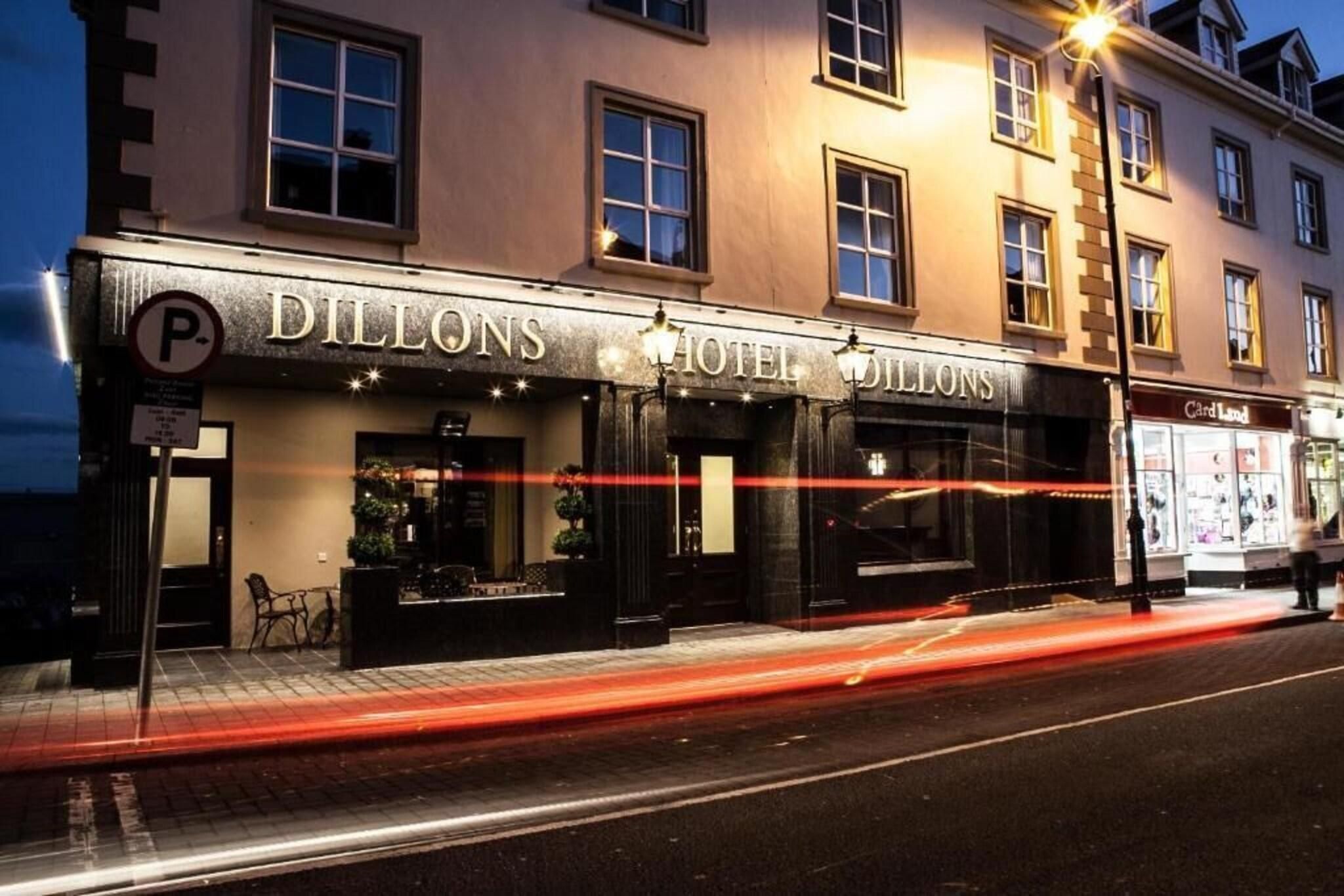 A hotel named 'Dillons Hotel' with a signboard, a parking sign, and a Cardland store across the street.