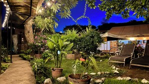 A garden area with potted plants, a pathway, and outdoor seating. - Hostal Antigueño - Hostel (Antigua Guatemala)