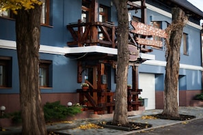 A rustic hotel with a blue facade, wooden balconies, and a signboard. - Art Rustic Hotel (Chisinau)