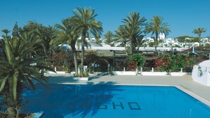 A swimming pool with the words "Club Shangho" painted on it, surrounded by palm trees and white buildings with blue roofs. - Sangho Club Zarzis (Zarzis)