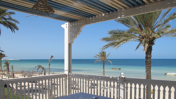 An outdoor dining area with a view of the beach and ocean. - Sangho Club Zarzis (Zarzis)