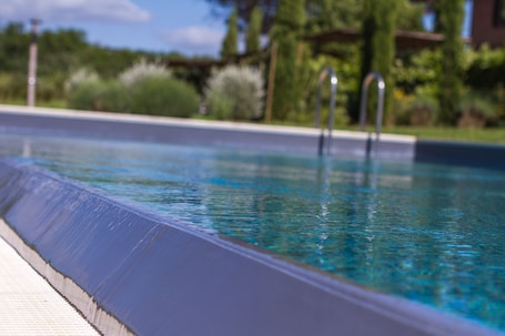 Una piscina al aire libre, sillones reclinables de piscina