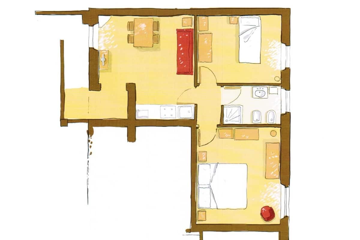 A floor plan of a hotel room with a bed, a desk, a chair, a bathroom, and a small kitchen area.