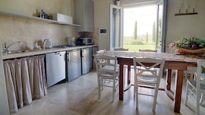 A compact kitchen with a dining area, a sink, a stove, and a microwave.