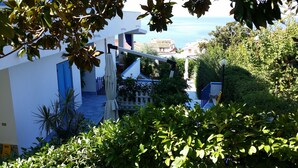 A residential building with a white exterior, a blue door, and a view of the sea. - B&B Villa Betta (Bonifati)