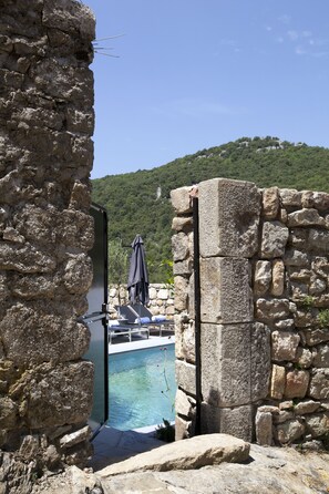 Una piscina al aire libre, sillones reclinables de piscina