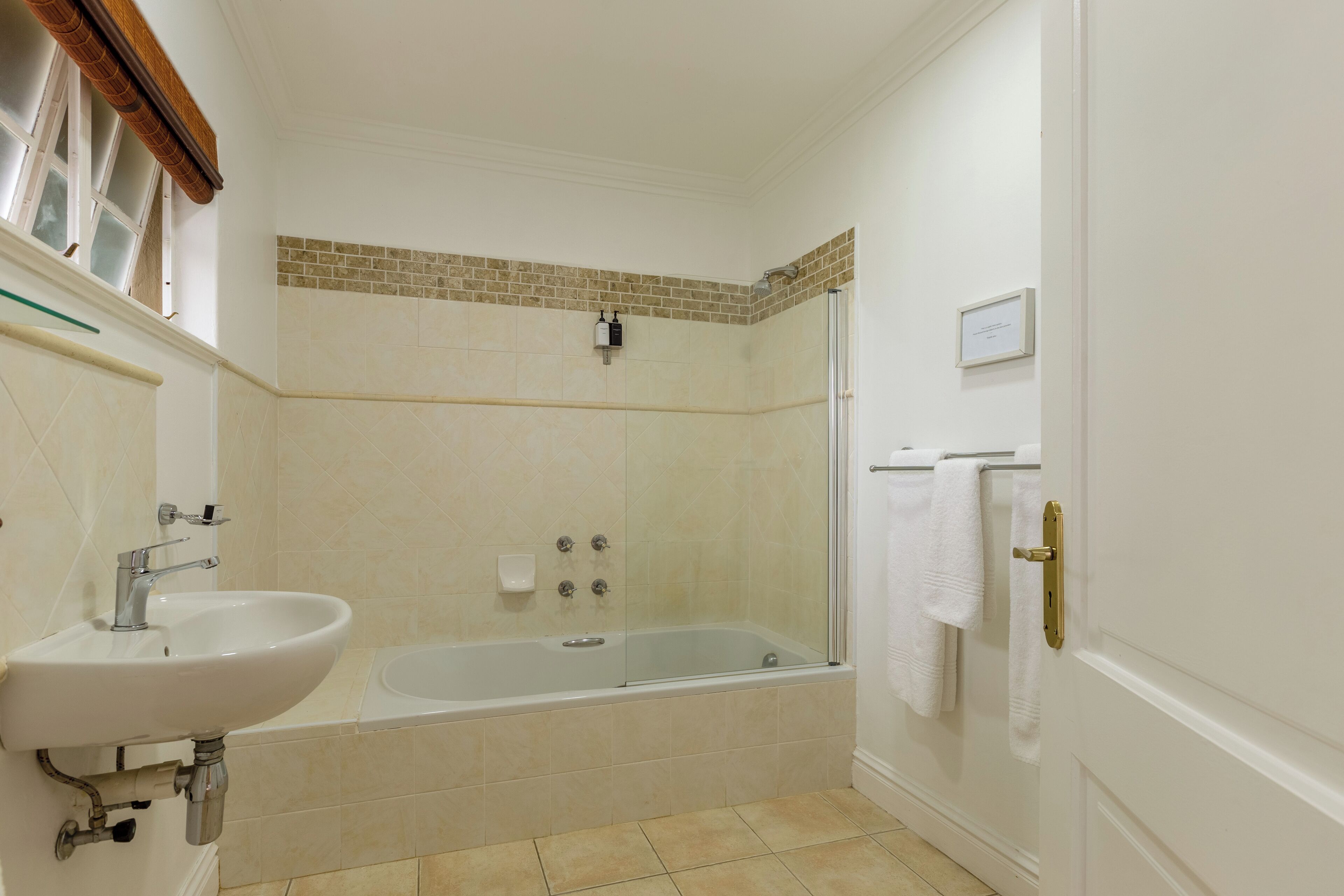 Un baño con lavamanos, bañera y zona de ducha.