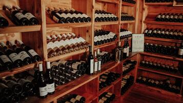 A wine cellar with wooden shelves stocked with various wine bottles.
