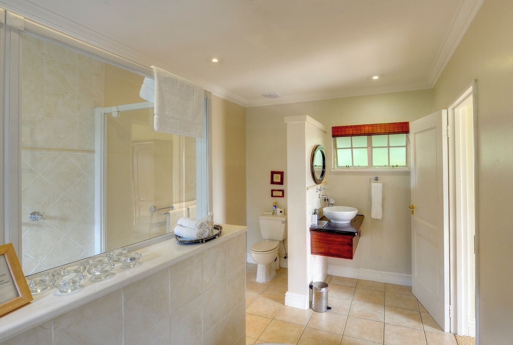 Een badkamer met een bad, een wastafel, een toilet en een spiegel.