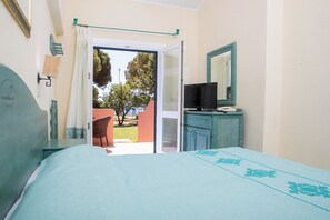 Una camera da letto con un letto, una televisione su un comò e vista sull'esterno.