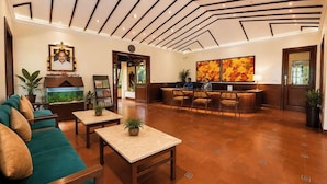 Een hotellobby met een receptiebalie, een zithoek en een groot aquarium.