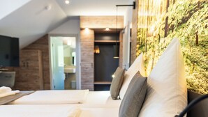 A modern hotel room with a large bed, a wooden headboard, and a wall-mounted TV. - Hotel Christel (Heimbuchenthal)