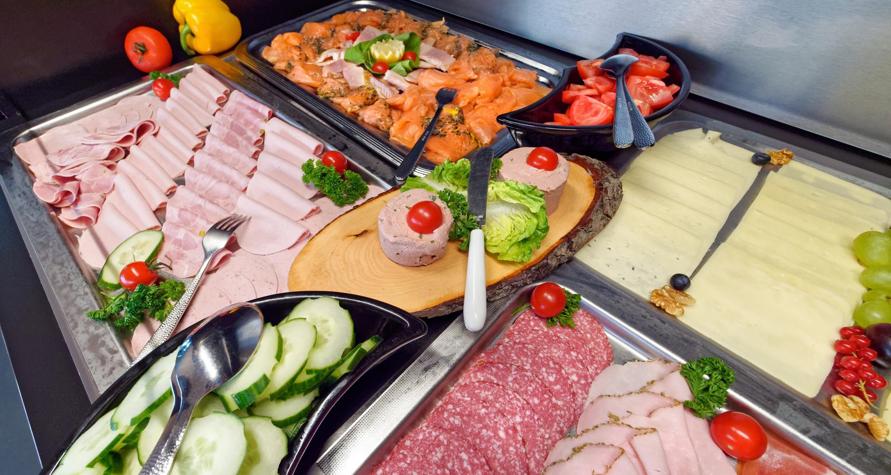 Un buffet proposant une variété de viandes, de fromages et de légumes.