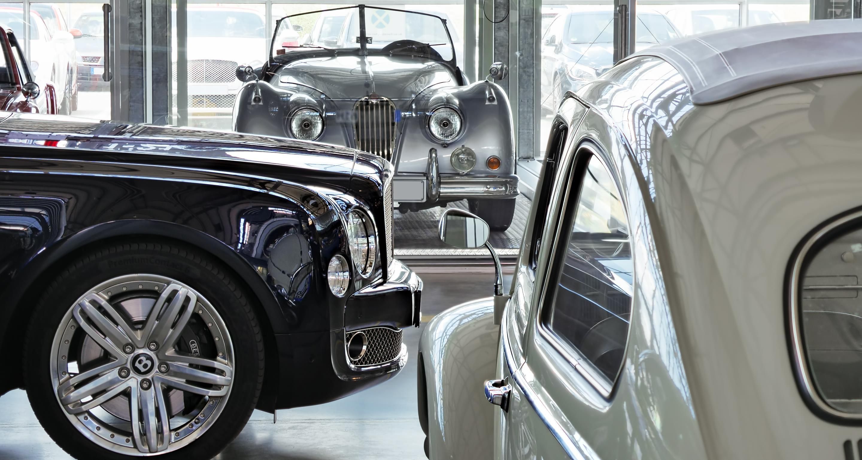 Una sala de exhibición de autos clásicos con vehículos antiguos.
