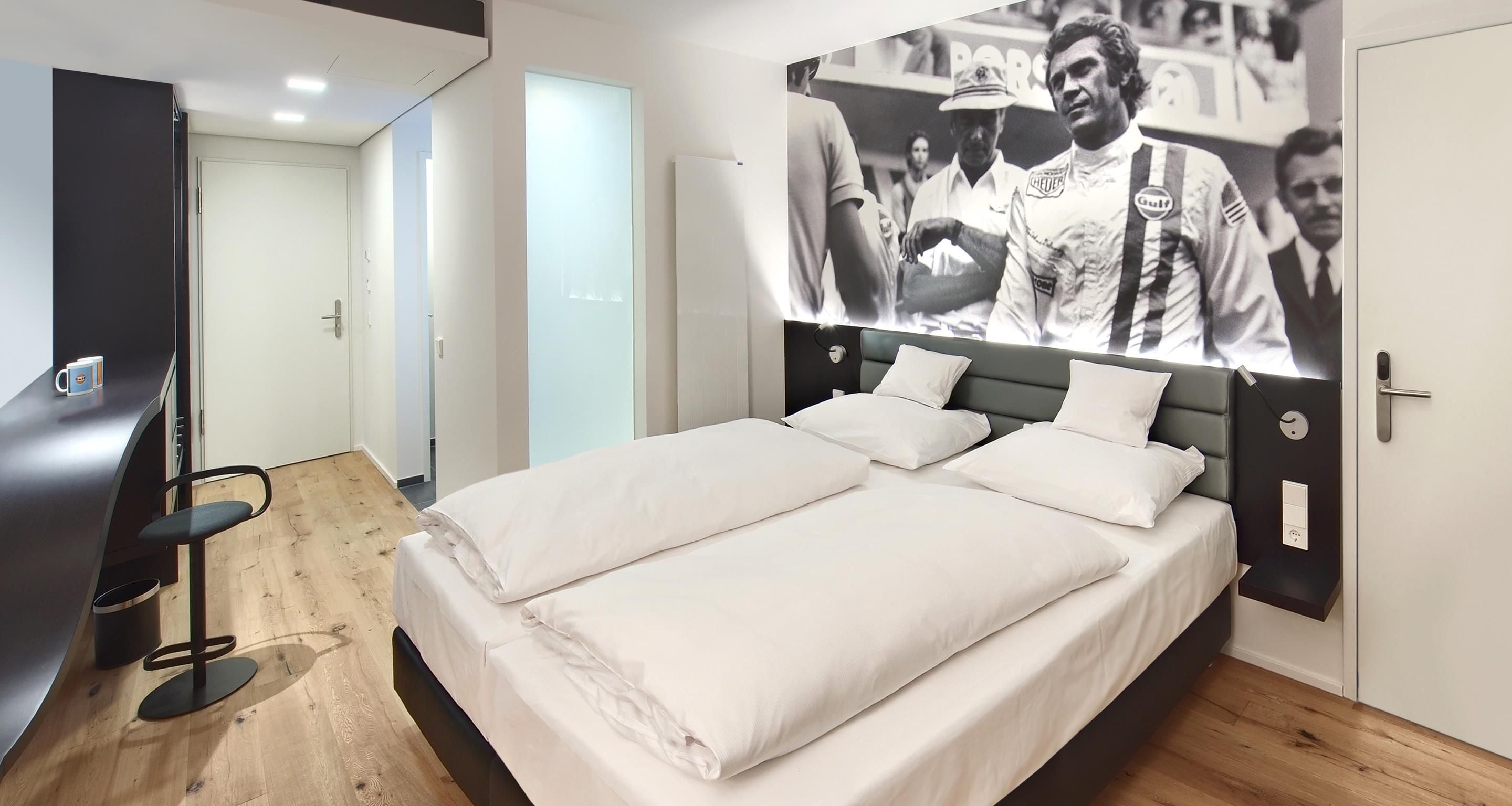 A modern hotel room with a large bed, a desk, and a wall-mounted TV.