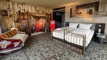 A bedroom with a vintage car-themed decor, a brick-patterned floor, and a bed with a metal frame.