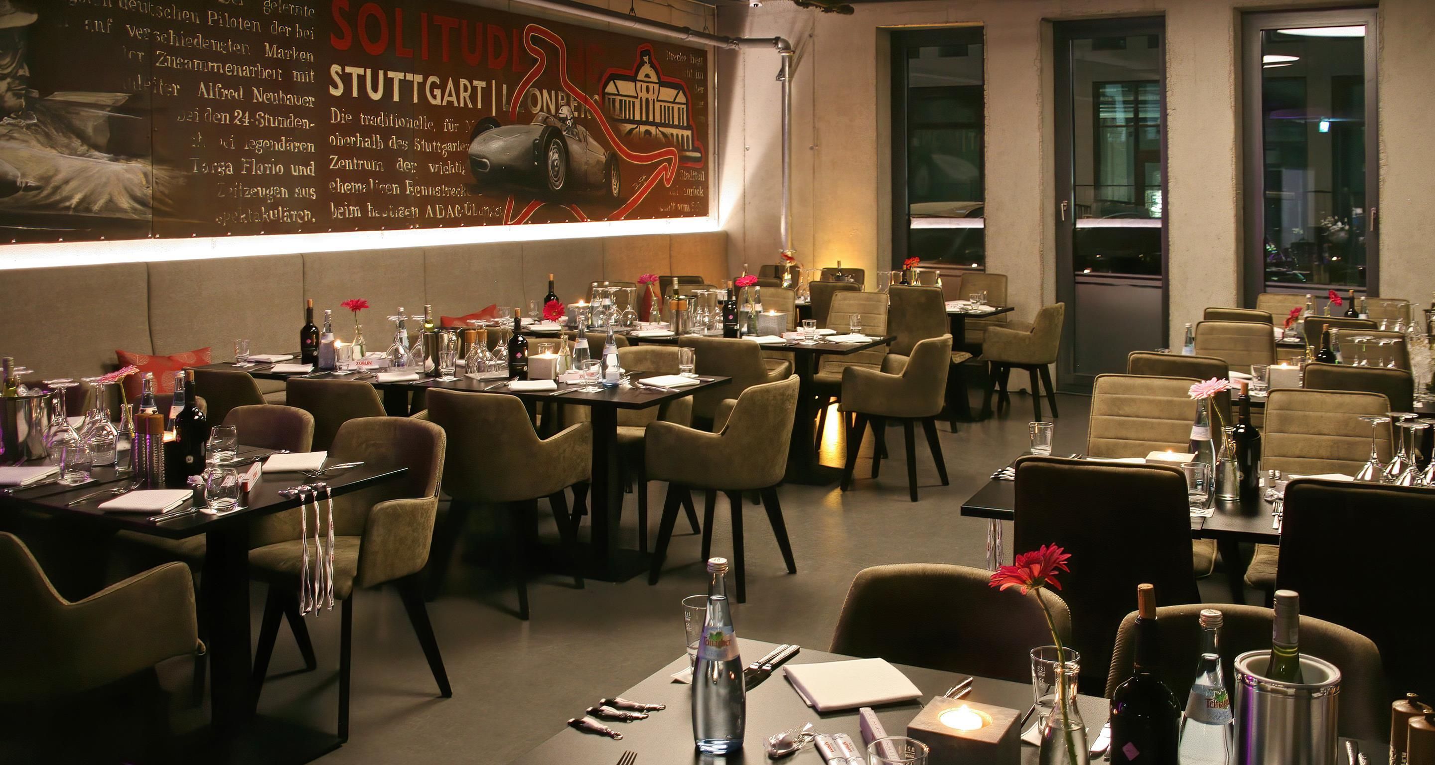 A restaurant with tables set for dining, chairs, and a wall with a poster.