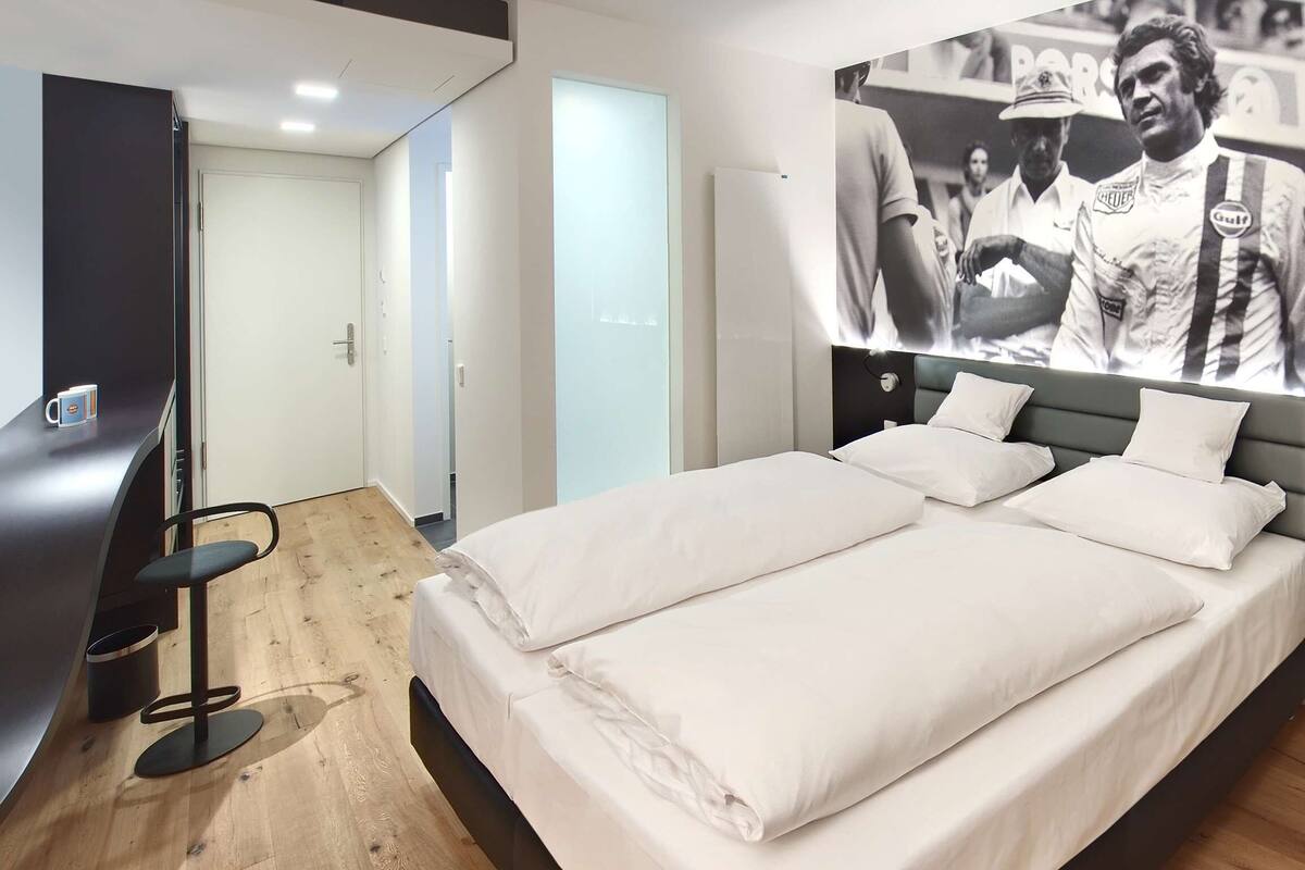 Una habitación de hotel moderna con una cama grande, un escritorio y una silla.
