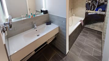 A modern bathroom with a white sink, mirror, and a shower area.