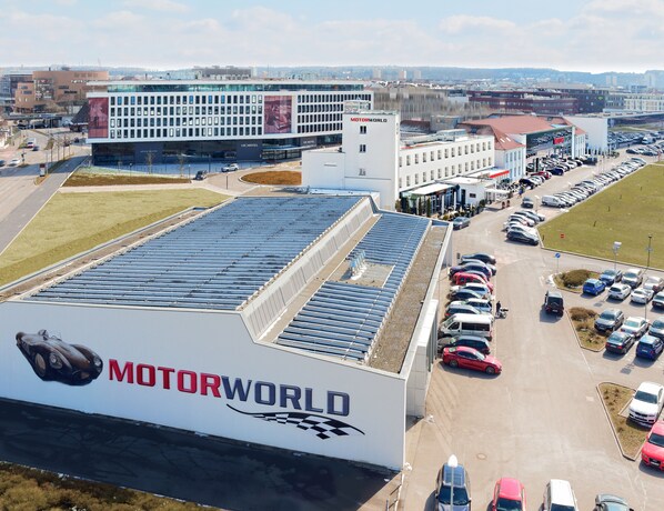 A large building with a solar panel roof and a prominent 'MOTORWORLD' sign. - V8 Hotel Motorworld Region Stuttgart, BW Premier Collection (Boeblingen)