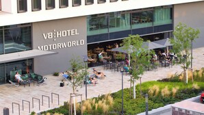 A V8 Hotel Motorworld with outdoor seating and a landscaped garden area. - V8 Hotel Motorworld Region Stuttgart, BW Premier Collection (Boeblingen)