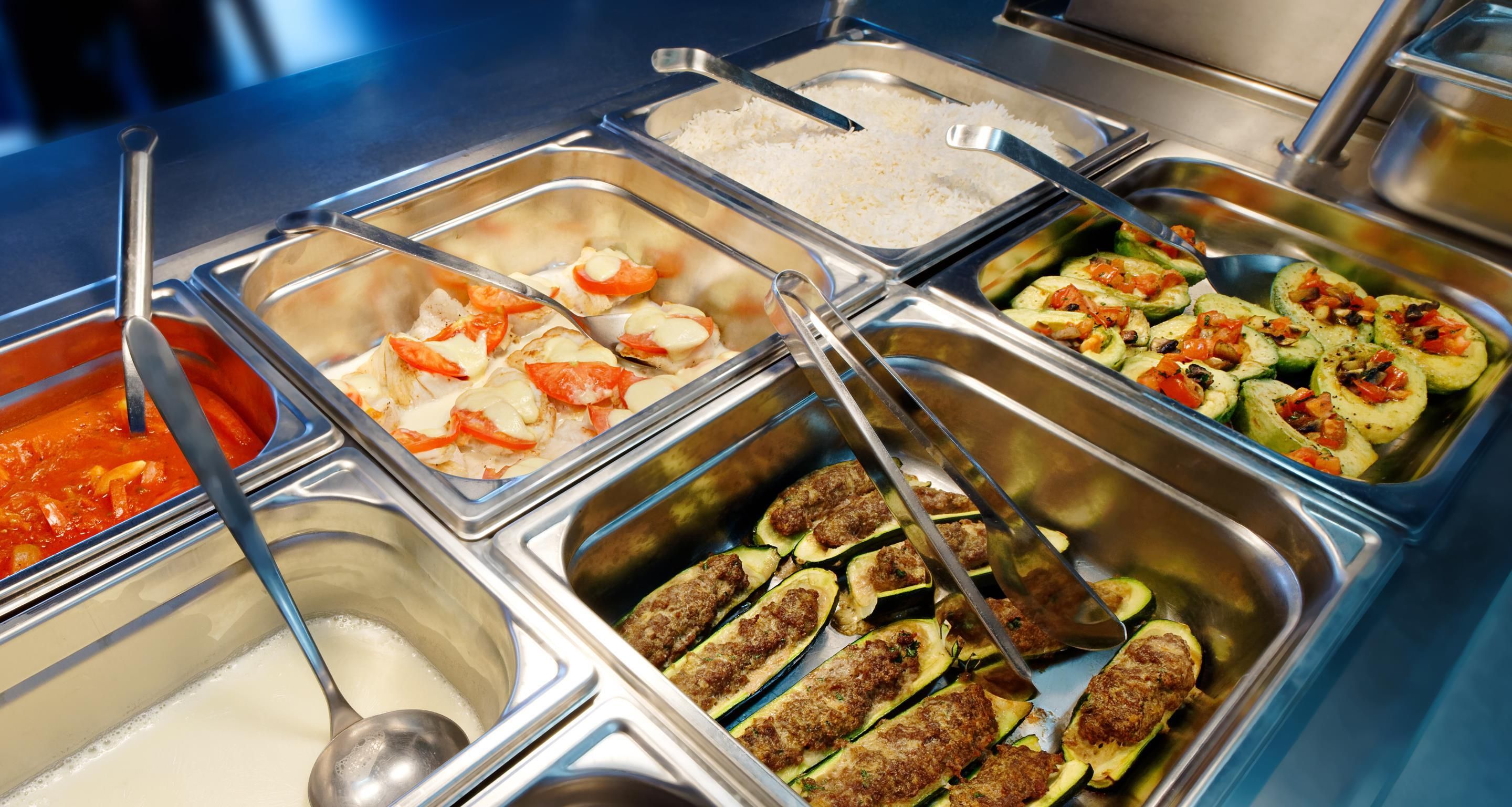 A buffet with various food options including rice, seafood, and vegetables.