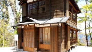 A traditional wooden building with a two-story structure, large sliding doors, and a balcony.