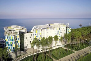 A modern hotel with a unique architectural design, featuring a curved facade and multiple levels. - Autograph Collection Paragraph Resort & Spa Shekvetili (Shekhvetili)