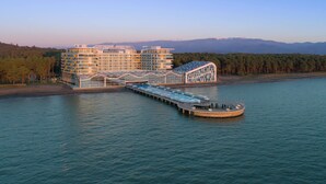 A cruise ship docked at a pier with a large building in the background. - Autograph Collection Paragraph Resort & Spa Shekvetili (Shekhvetili)