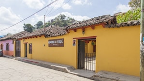 Un edificio amarillo con un letrero que dice 'Adope & Teja hotel'.