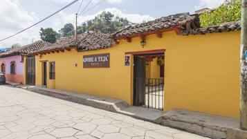 Un edificio amarillo con un letrero que dice 'Adope & Teja hotel'.
