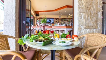 A table set with various dishes and a bar in the background.