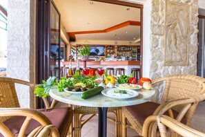 Una mesa servida con diferentes platos y un bar al fondo.