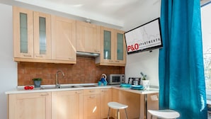 Una cocina moderna con armarios de madera, un lavamanos de acero inoxidable y una cortina azul.