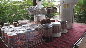 A table with various containers and a water dispenser. - Country Inn 304 (Si Maha Phot)