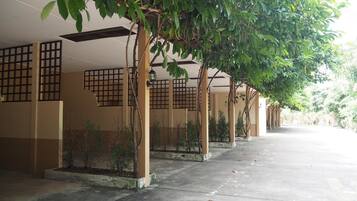A corridor with traditional-style buildings, featuring wooden lattice windows and a tiled floor.