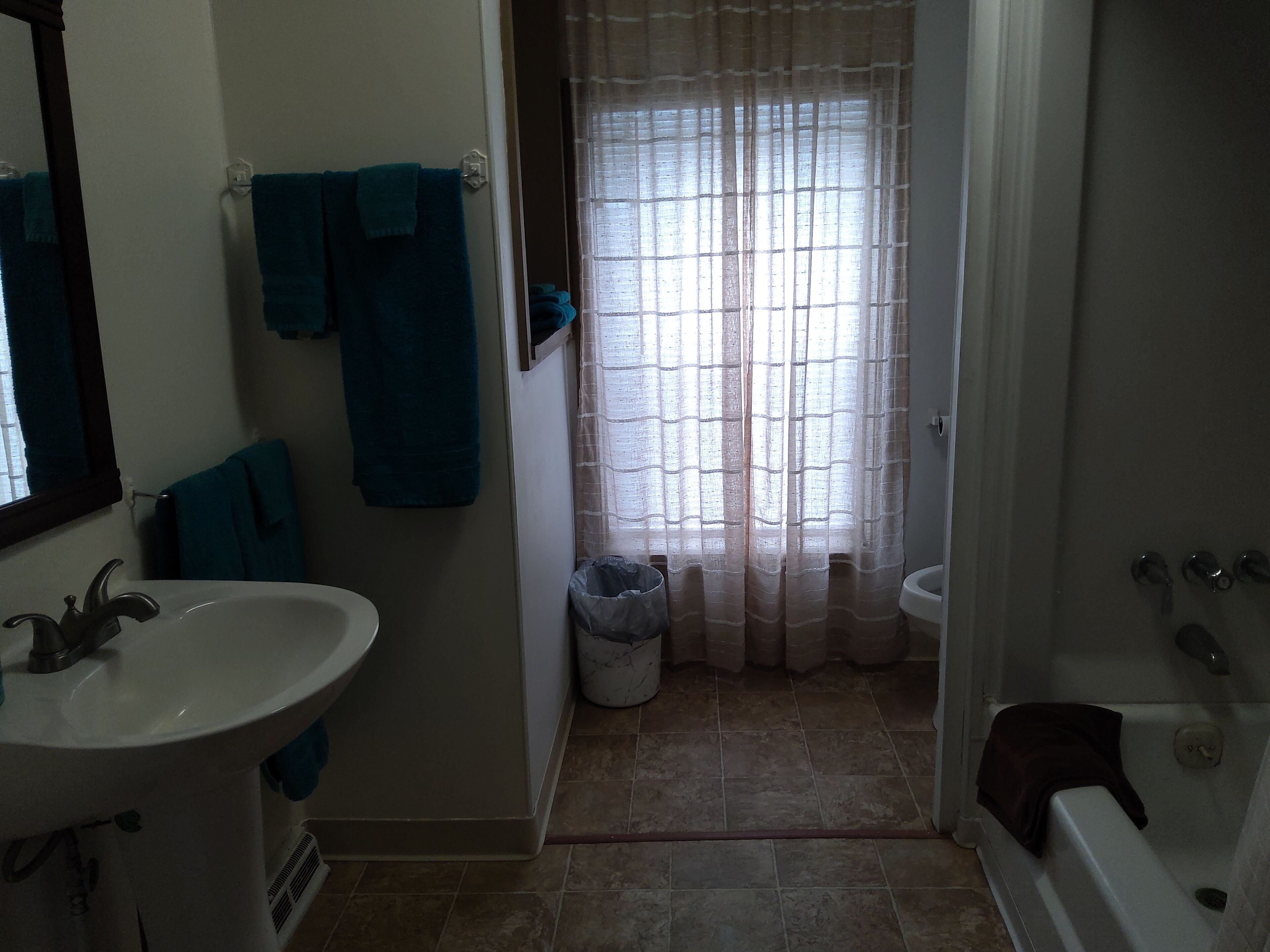 A bathroom with a sink, mirror, and a shower area.