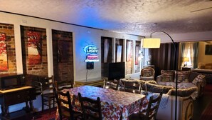 Una habitación acogedora con una mesa de comedor, sillas, un sofá y un televisor.
