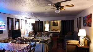 Una sala de estar acogedora con comedor, ventilador de techo y televisor.