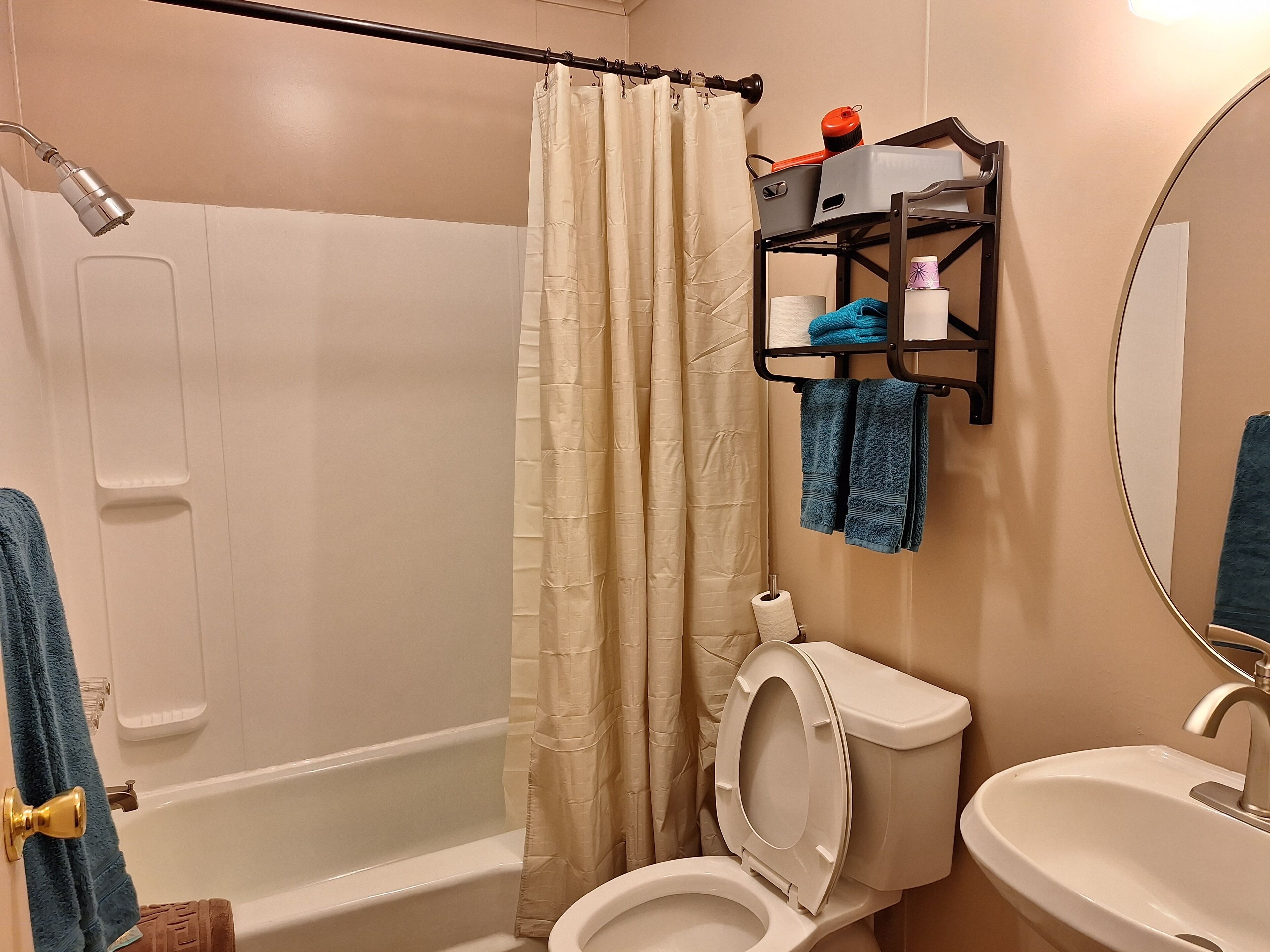 Un baño con bañera, inodoro, lavamanos y cortina de ducha.