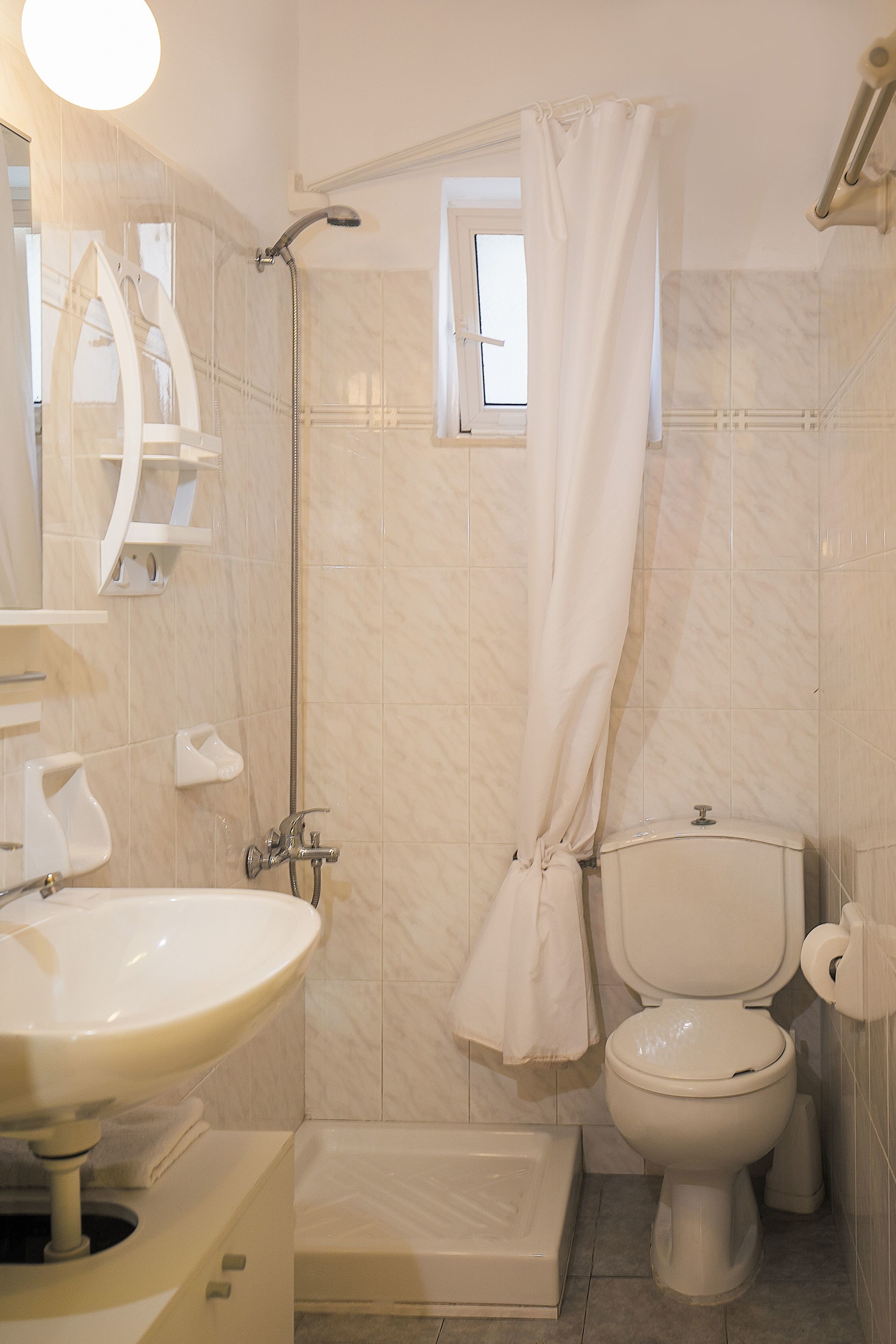 A bathroom with a shower, toilet, and sink.