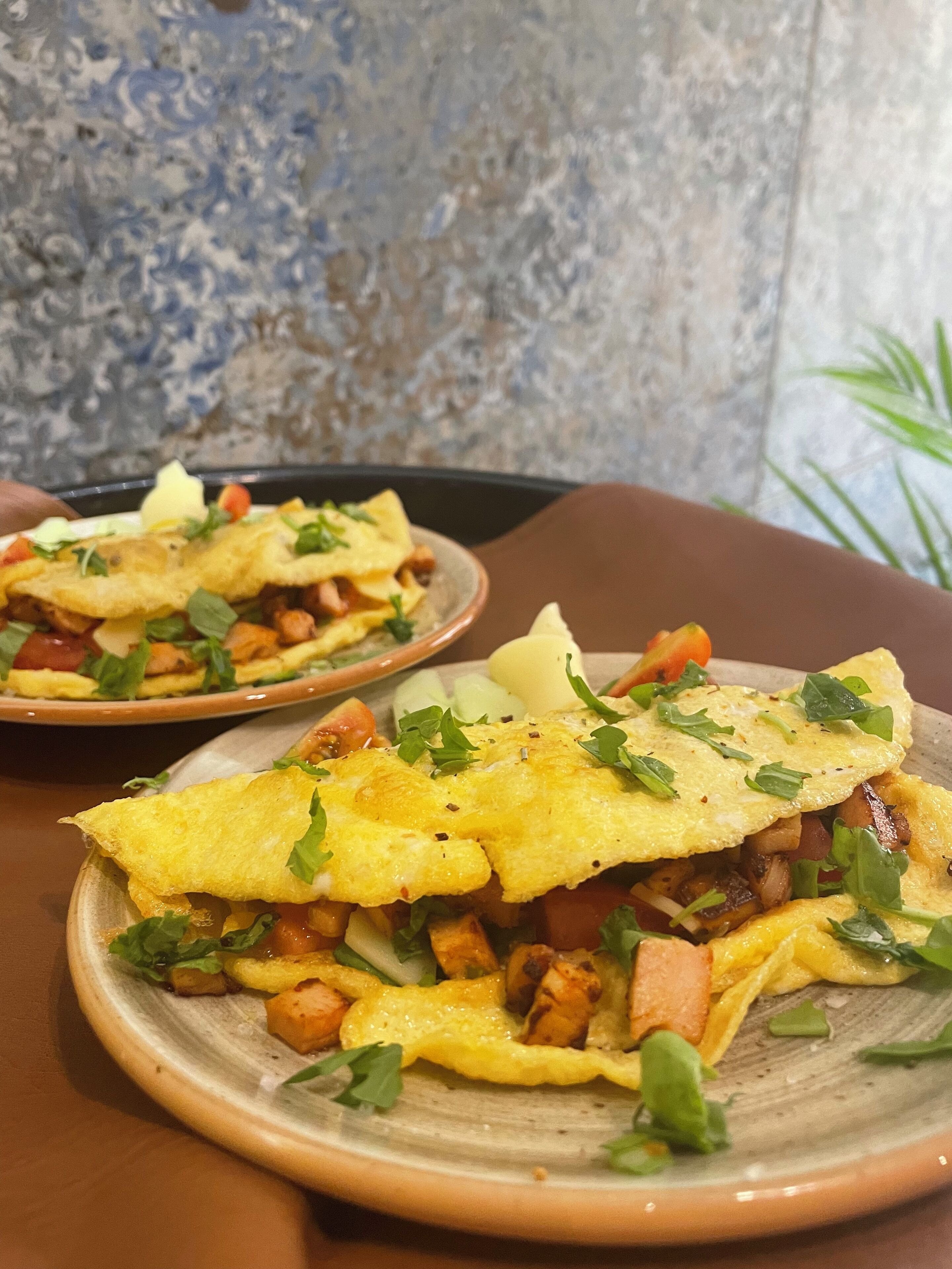 A plate of food with a crispy omelette, vegetables, and herbs.