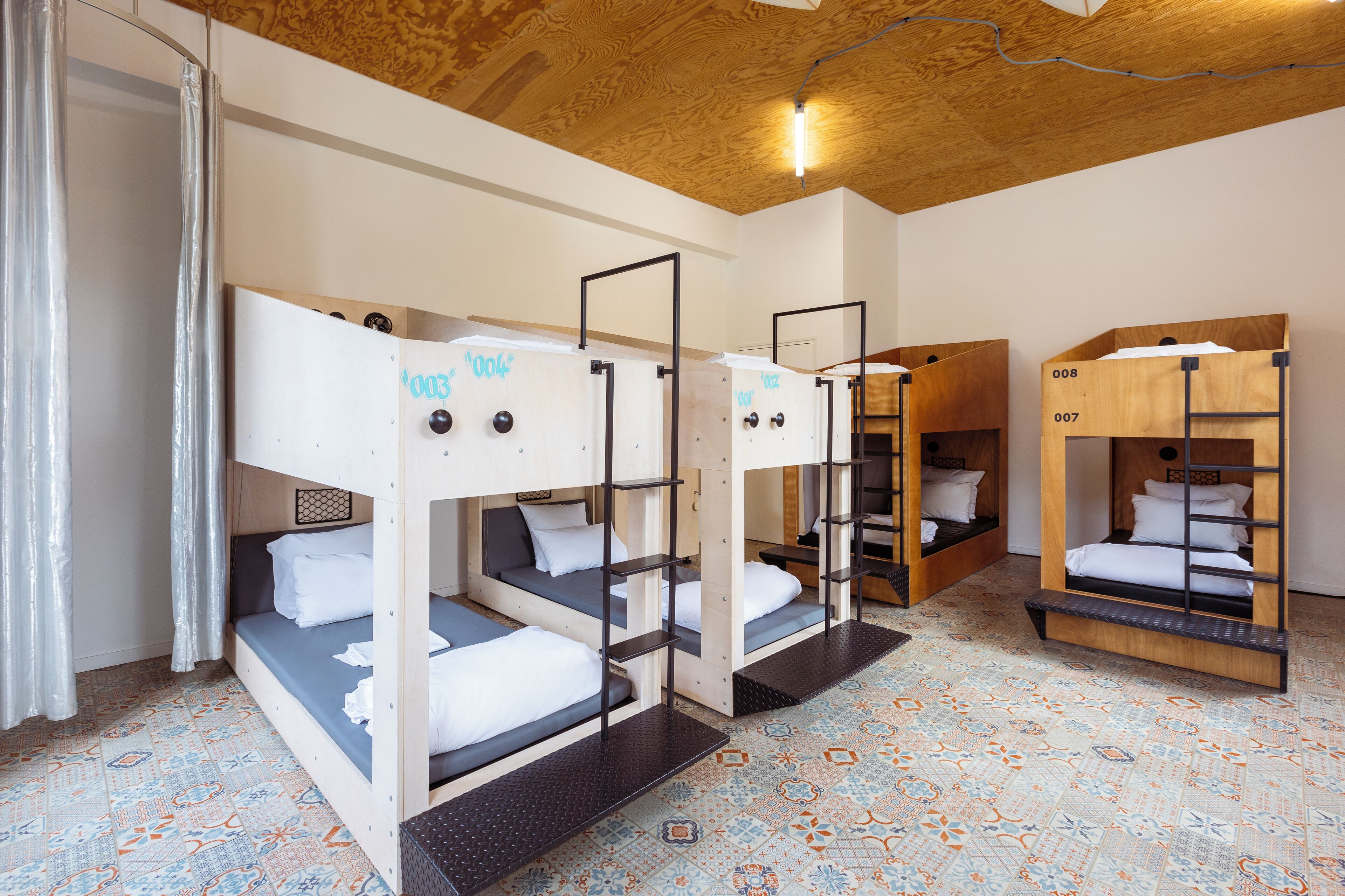 A room with bunk beds, numbered beds, and a patterned floor.