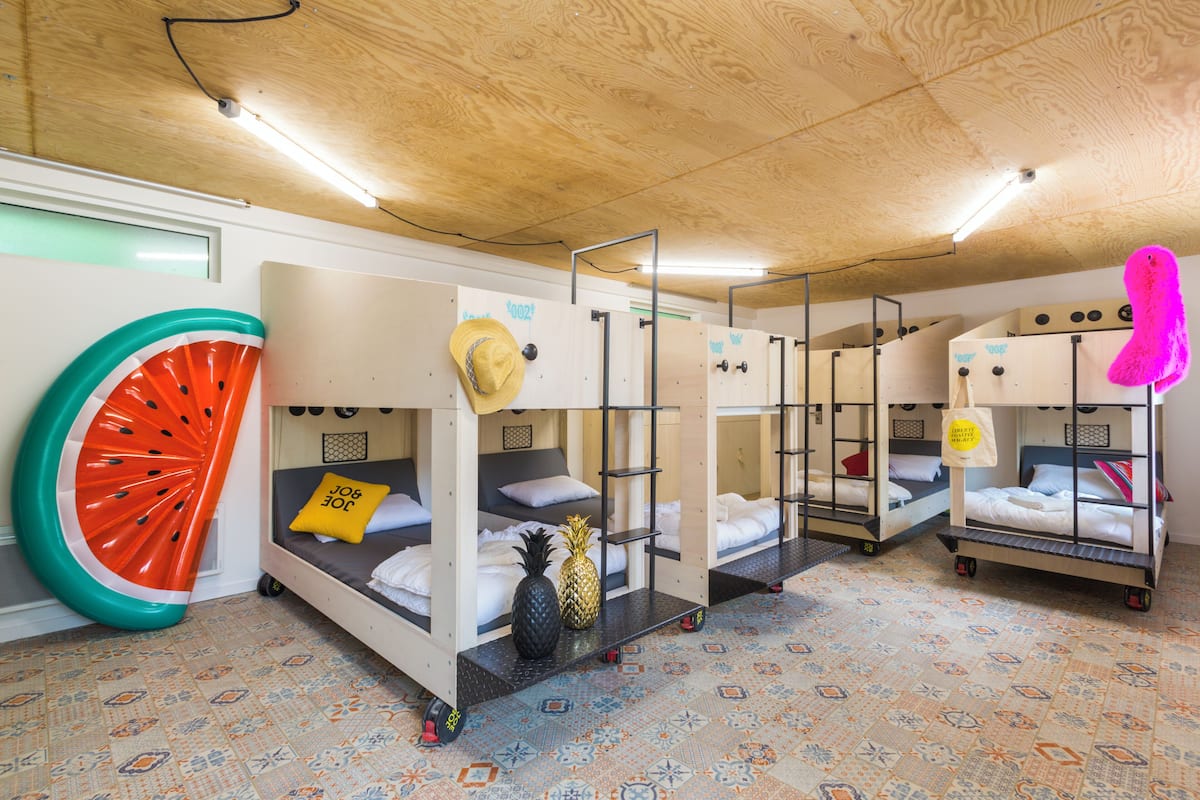 Ein Zimmer mit Etagenbetten, einer großen Wassermelonen-Dekoration und einem gemusterten Boden.
