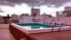 A rooftop swimming pool with a view of the cityscape. - Lofts & Suites Rosario (Rosario)